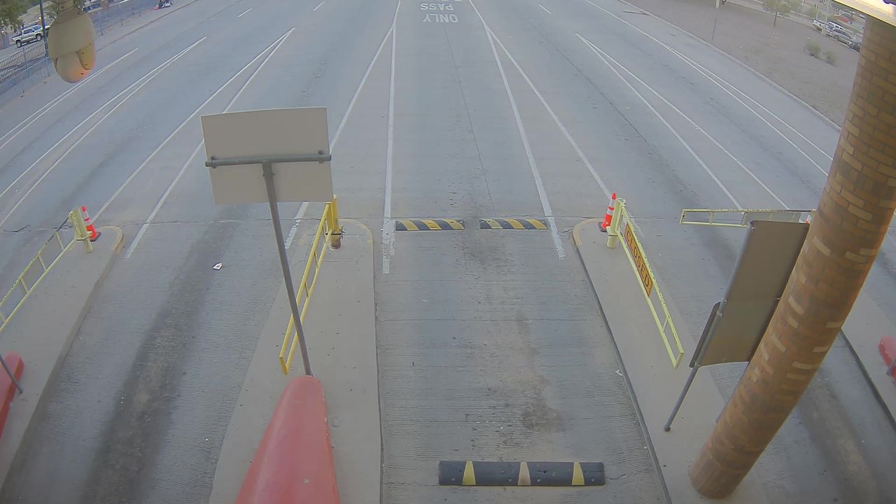Empty roadway with construction barriers and cones, indicating a closed lane; no vehicles or workers visible.