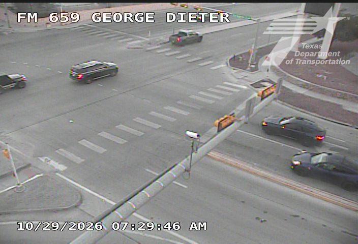 Vehicles navigate a multi-lane intersection with crosswalks and traffic control devices; no visible incidents or road work.