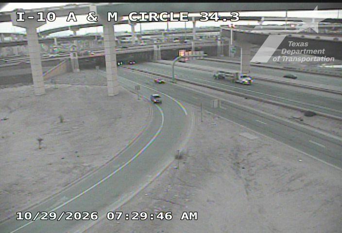 A curved highway approaches an overpass with light traffic moving in both directions; no visible incidents or road work.