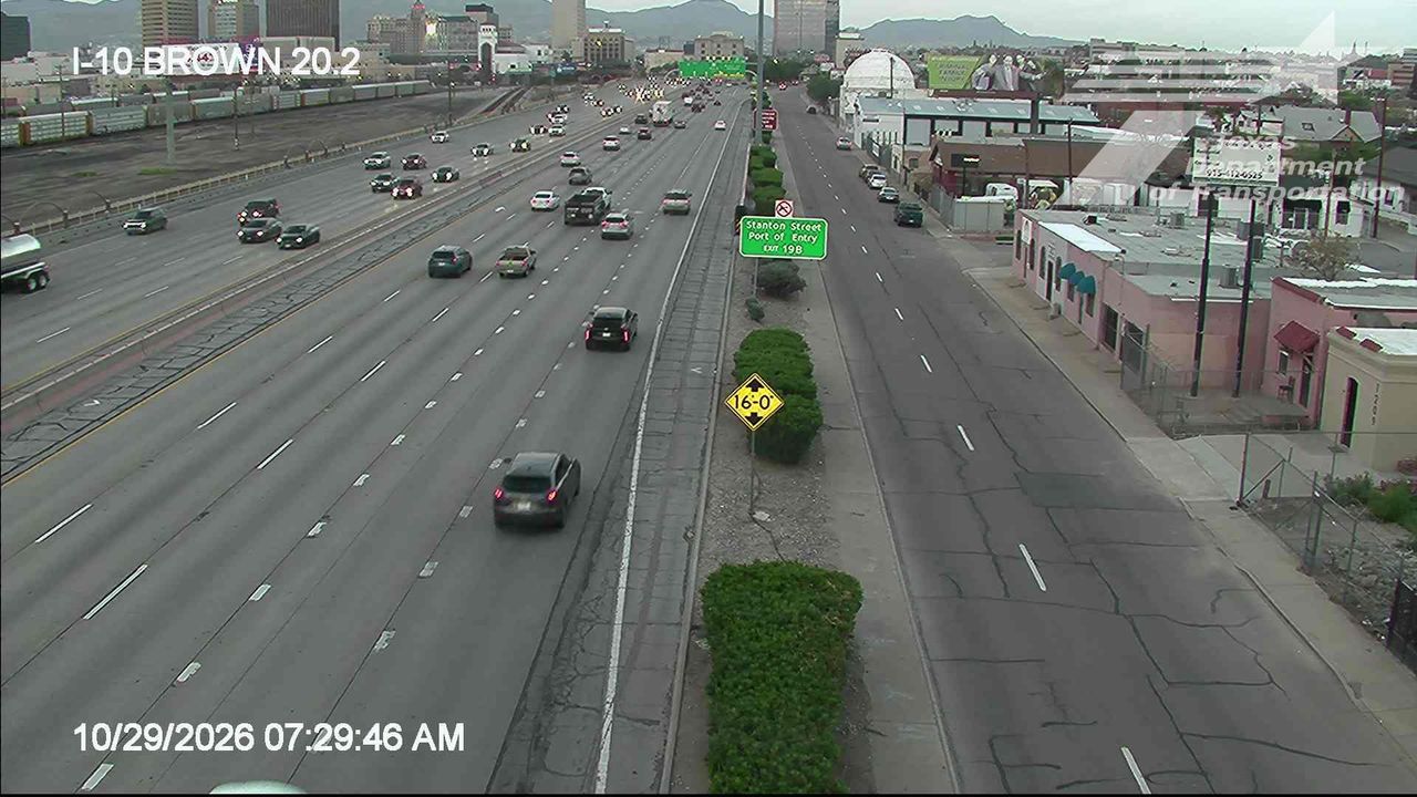 Multi-lane highway with moderate traffic flowing in both directions, separated by a median with greenery and signage; no visible incidents or road work.