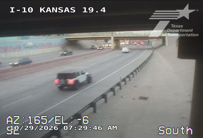 Vehicles move freely on a multi-lane highway under an overpass, with no visible incidents or road work.