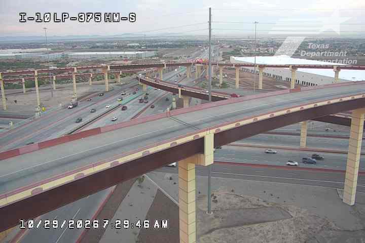 Multi-level highway interchange with moderate traffic flow under overpasses; no visible incidents or road work.