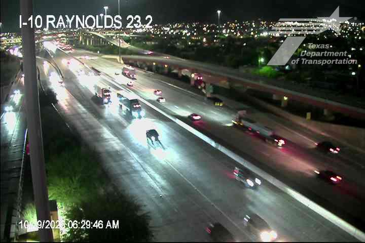 Nighttime highway with moderate traffic flow under wet conditions, illuminated by vehicle headlights and streetlights; no visible incidents or road work.