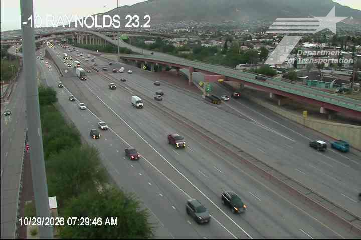Multi-lane highway with moderate traffic flowing in both directions under an overpass, with no visible incidents or road work.