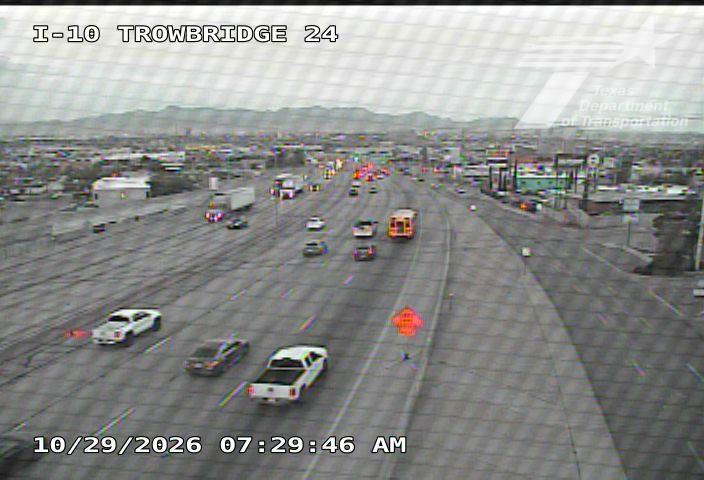 Multi-lane highway with moderate traffic flow, including passenger cars and trucks, under overcast skies with no visible incidents or road work zones.
