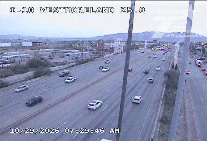 Multi-lane highway with moderate traffic flow, vehicles moving in both directions under clear skies.