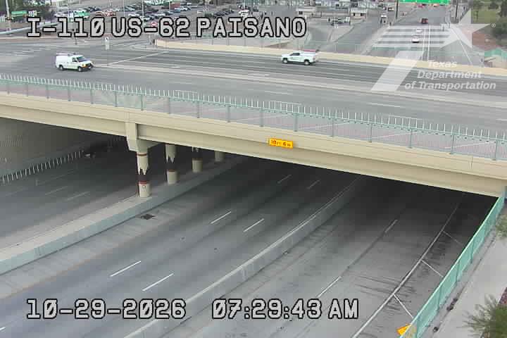 Multi-lane highway with light traffic under an overpass; two white work vans visible on the upper level, no active road work or incidents.