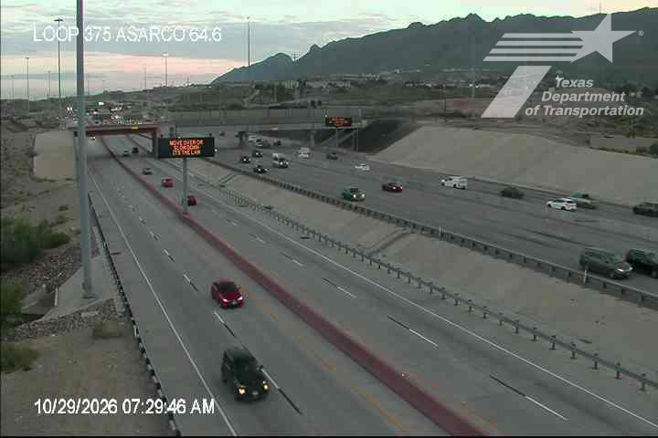 Multi-lane highway with moderate traffic flow under clear sky, vehicles moving freely across lanes with no visible incidents or road work.