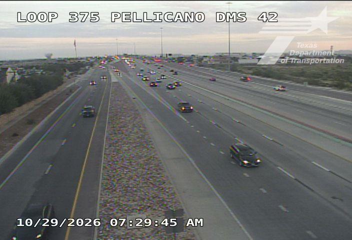Multi-lane highway with moderate traffic flow under clear skies, vehicles moving steadily across lanes with no visible incidents or road work.
