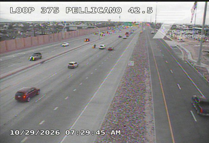 Multi-lane highway with moderate traffic flow, vehicles moving freely in both directions, no visible incidents or road work, overcast sky with good visibility.