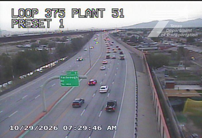 Multi-lane highway with moderate traffic flow, vehicles moving in both directions under clear skies.