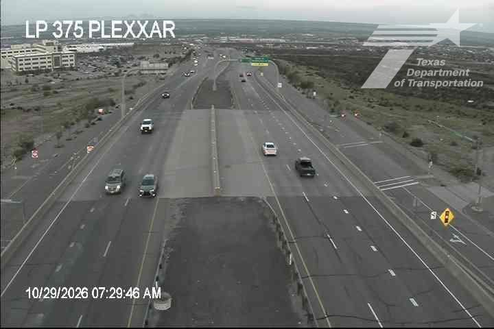 Multi-lane highway with moderate traffic flowing under an overpass; no visible incidents or road work; weather appears overcast with good visibility.