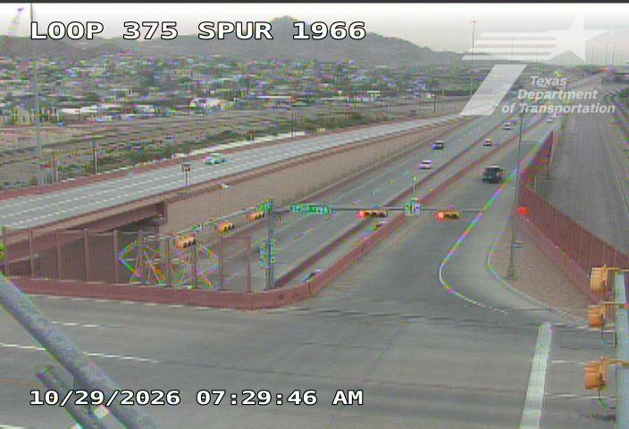 Light traffic flows on a multi-lane highway with an overpass and traffic signals; no visible work zones or incidents.