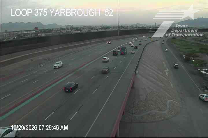 Multi-lane highway with moderate traffic flow under clear skies, vehicles moving steadily across lanes with no visible incidents or road work.