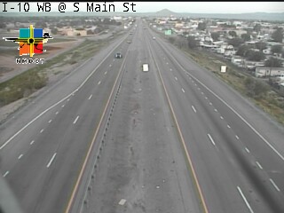 A multi-lane highway with light traffic moving in both directions, no visible incidents or road work, under overcast skies.