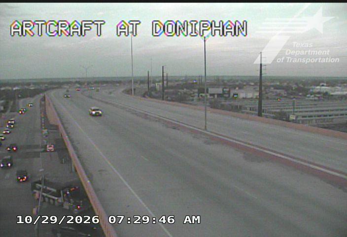 Light traffic flows on a multi-lane highway with a few vehicles and a large truck visible, under overcast skies with no apparent work zones or incidents.