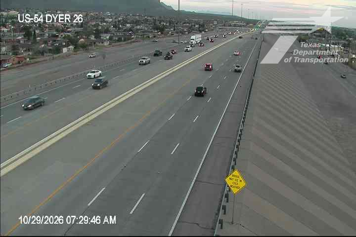 Multi-lane highway with moderate traffic flow, vehicles moving in both directions under clear skies.