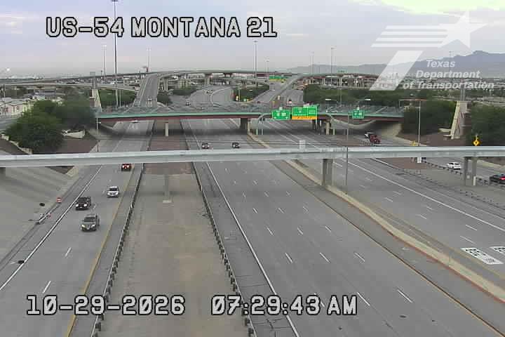 Multi-lane highway with light traffic flowing under an overpass, clear weather with no visible incidents or road work.