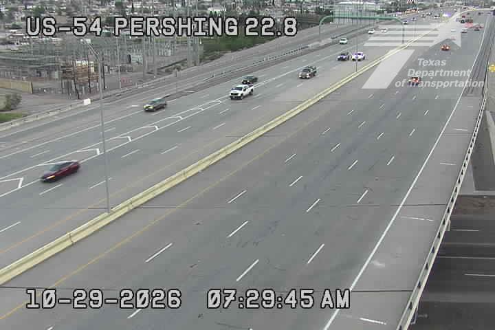 Multi-lane highway with moderate traffic flow, vehicles moving in both directions under clear weather conditions.