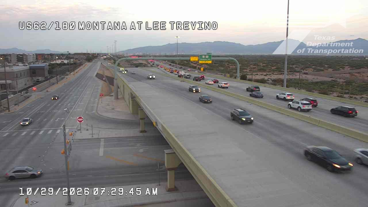 Multi-lane highway with moderate traffic flowing under an overpass; vehicles moving freely with no visible incidents or road work.